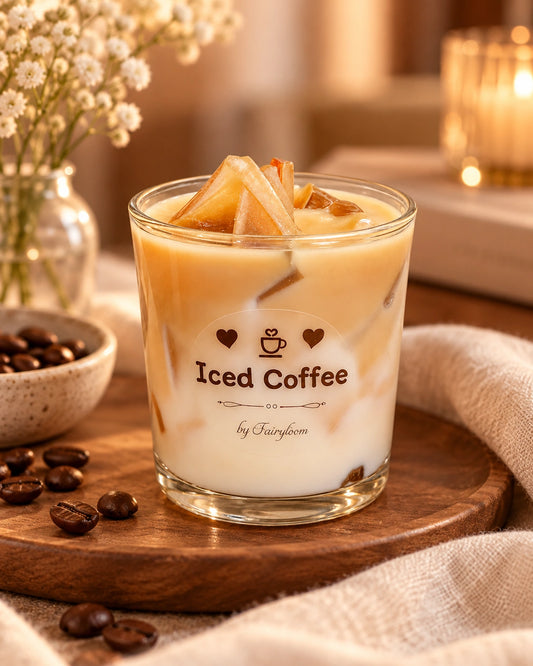 Handgemachte Fairyloom Iced Coffee Kerze auf einem Holzteller mit Kaffeebohnen und zarten Blumen.